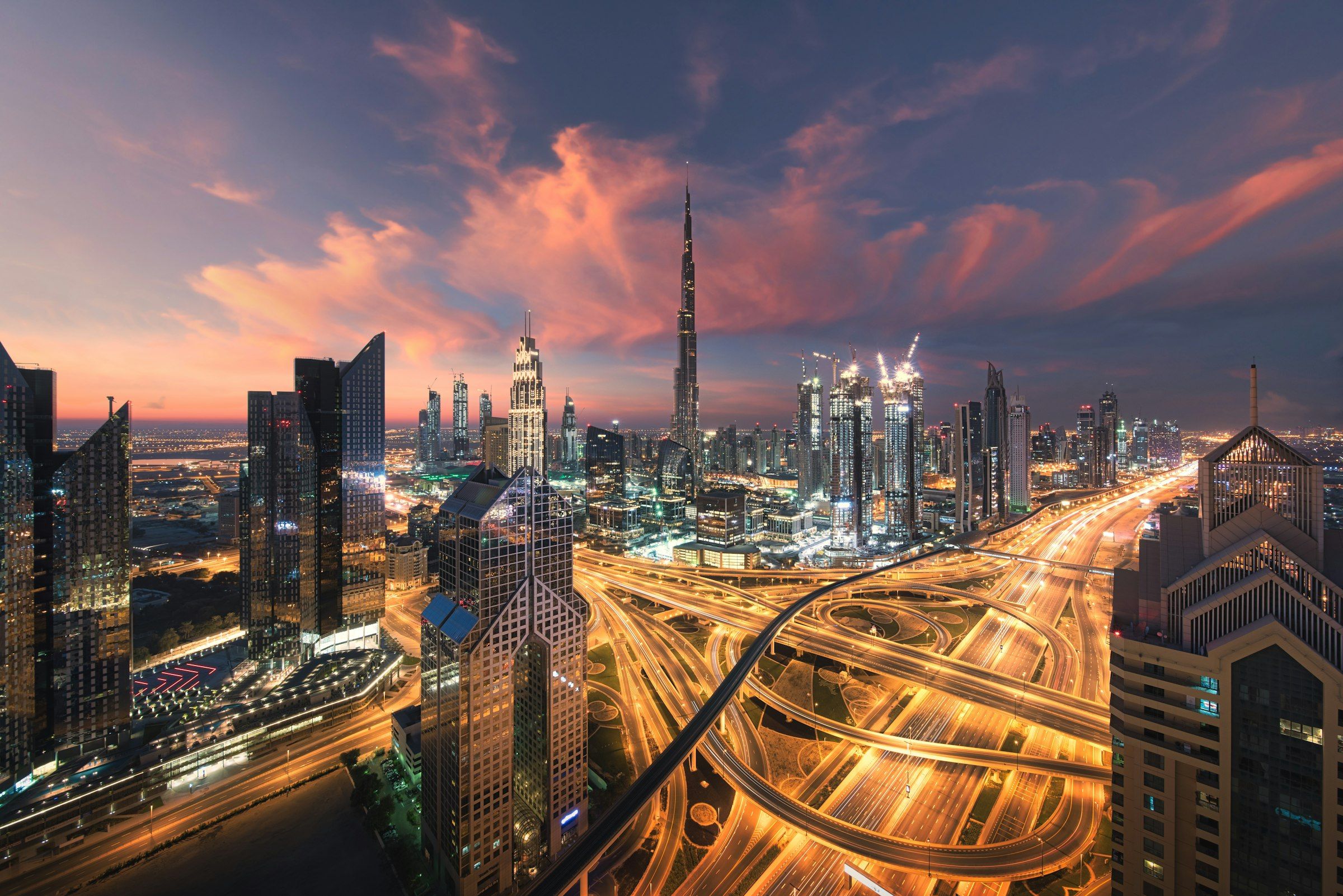 Dubai at dusk: the Burj Khalifa above a web of lit motorways